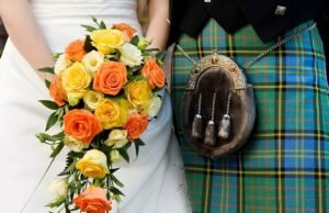 The Kilt and Sporan are the traditional Scottish Highland dress for men to wear on their wedding day in Scotland. The bride is dressed in white and holds a bouquet of flowers.