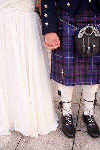 Scottish bride and groom in formalwear, including wedding gown and kilt.