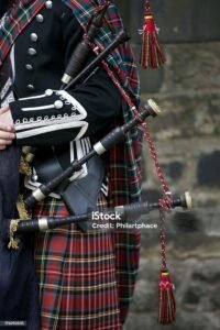 "Close up of the accessory of a Scottish bagpiper clad in a traditional scottish tartan holding the Scottish bagpipe. Royal Stewart tartan. Outdoor shot in the castle of Edinburgh, Scotland. XXXL (Canon Eos 1Ds Mark III)"